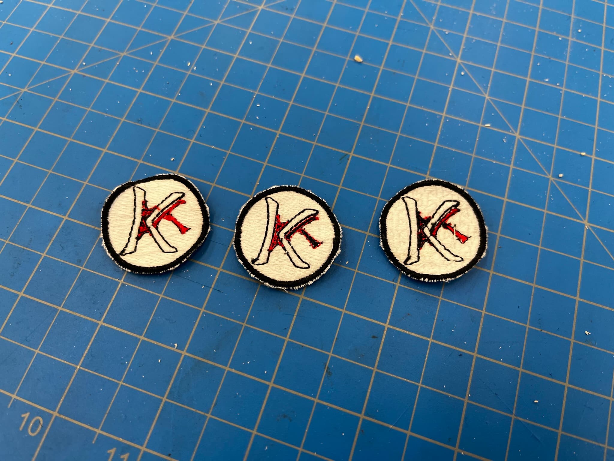 Three embroidered Impakt Beanies logo patches created during product testing